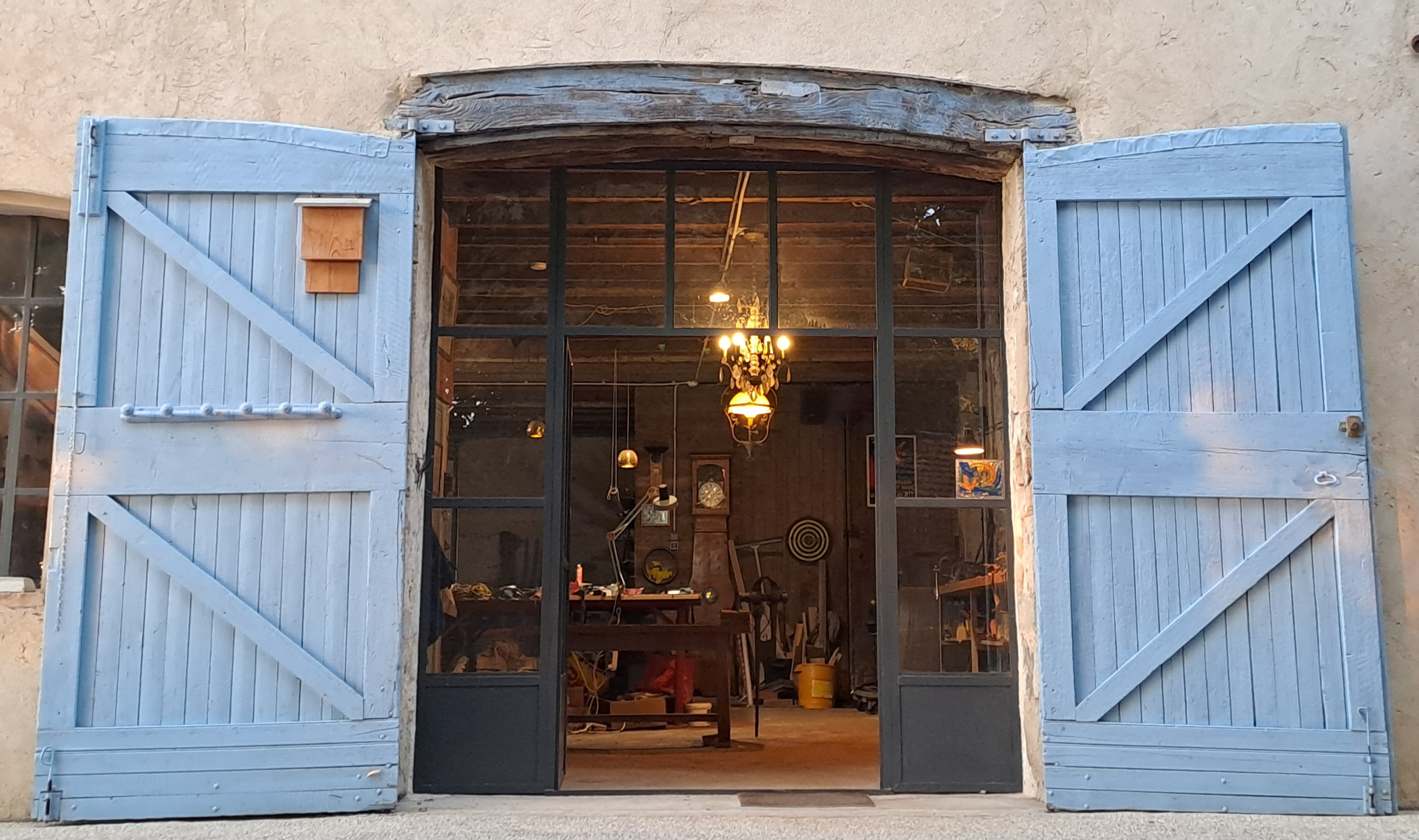 Entrée de l’atelier avec volets bleus ouverts