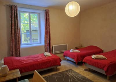 Chambre avec deux lits et rideaux rouges
